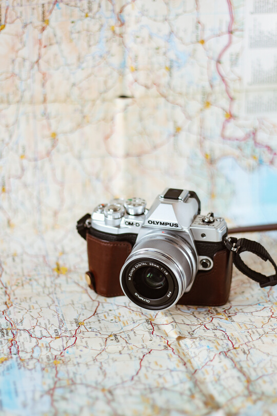 Retro photo camera with lens on paper map